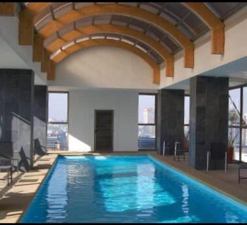 duży basen z niebieską wodą w budynku w obiekcie Alcantara'S Merced 562 w mieście Santiago