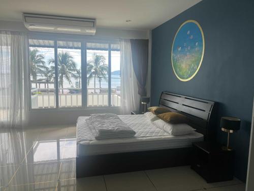 a bedroom with a bed and a window with a beach at Panwa Beach Side in Phuket Town