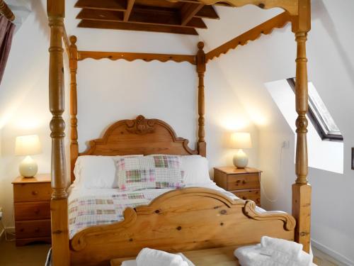 Boreland of ColvendにあるHolly Cottage - 28140のベッドルーム(木製の四柱式ベッド1台付)
