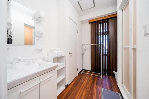 a white bathroom with a sink and a mirror at Skytree Apartment Self Check-in in Tokyo