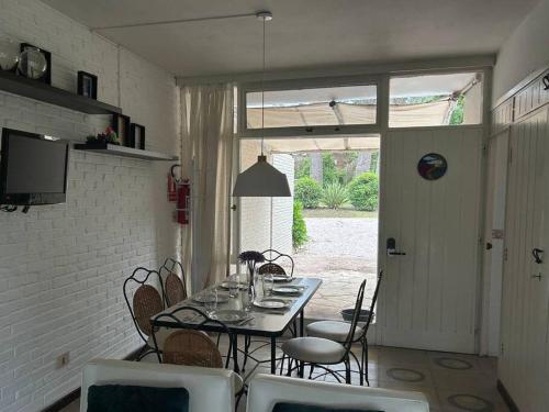 a dining room with a table and chairs and a window at Aurelia. Dúplex en complejo cerrado en San Rafael in Punta del Este