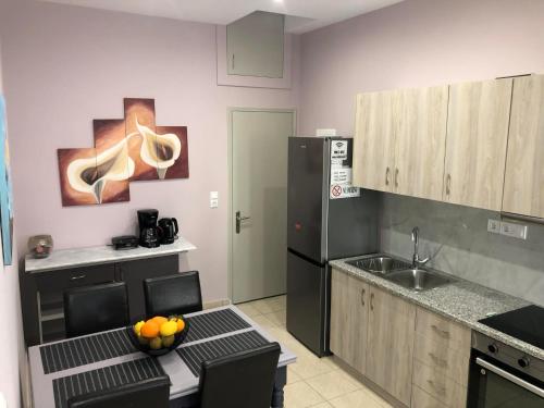 a kitchen with a black refrigerator and a table with fruit on it at Aktia Apartments, Preveza in Preveza