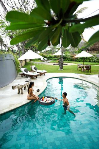 two people playing in a swimming pool at Pondok Santi Estate in Gili Trawangan