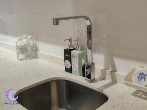 怡保的住宿－Muji 40 Winks Horizon 3-BR Retreat，柜台上的水槽,上面放有两瓶肥皂