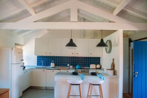 a kitchen with white cabinets and blue tile floors at Just Like Home - Casa João da Xica in Caminha