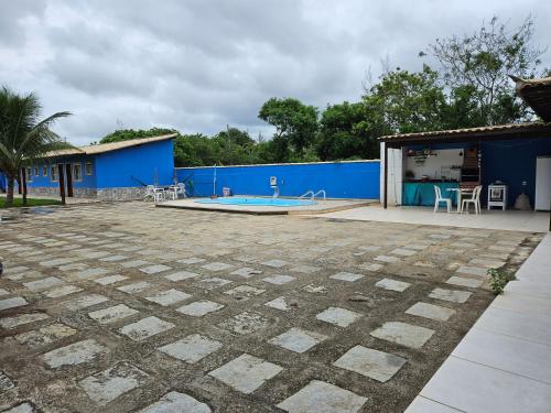 une terrasse avec un bâtiment bleu et une piscine dans l'établissement Pousada On Home, à Búzios