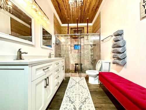 a bathroom with a red bench in front of a shower at Fleur De Lis Mansion in New Orleans