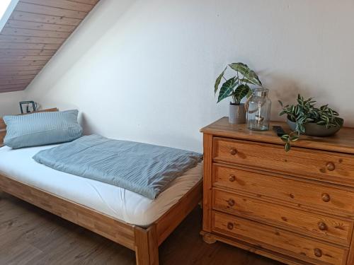 a bedroom with a bed and a wooden dresser at Bio Kinder Erlebnis Bauernhof Voit in Söchtenau