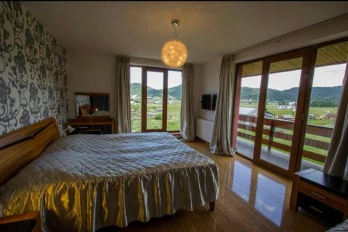 a bedroom with a bed and a large window at RED HOUSE in Bakuriani