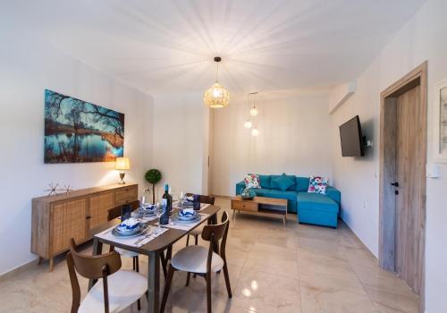 a living room with a dining table and a blue couch at Ruellia Luxury Apartments in Lefkada Town