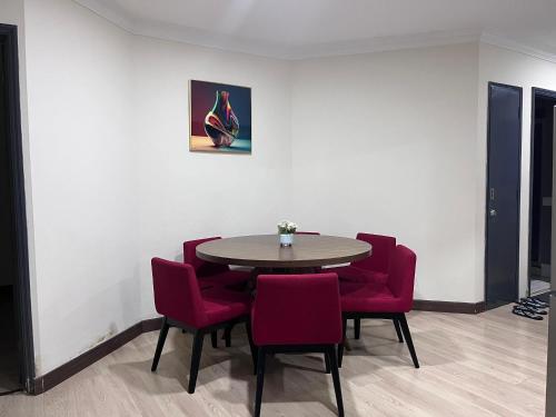 a room with a table and red chairs at Riverbank Suite @ Waterfront KCH in Kuching