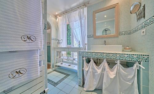 ein Bad mit einem Waschbecken und einem Spiegel in der Unterkunft VILLA MERCEDES B&b in La Londe-les-Maures