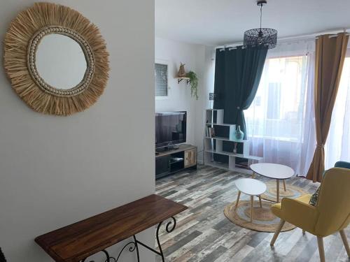 a living room with a mirror and a table at Appartement avec cours in Gien