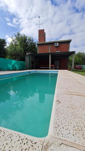 una gran piscina frente a una casa en Cabaña LA JUANA en 