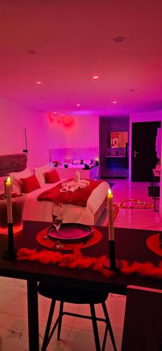 Cette chambre violette comprend un lit et une table avec des bougies. dans l'établissement Loft Détente & Spa du Tram, à Ronchamp