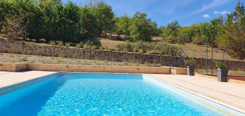 une piscine avec de l'eau bleue dans une cour dans l'établissement Mas provençal avec piscine et tennis, à Ongles