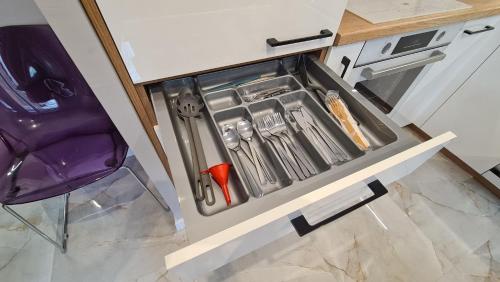 a drawer in a kitchen with utensils in it at Modlin Deluxe Suite in Nowy Dwór Mazowiecki