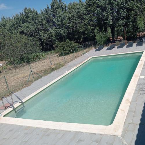une piscine avec de l'eau bleue dans une cour dans l'établissement Chambre d'hôtes les garrigues, à Piolenc