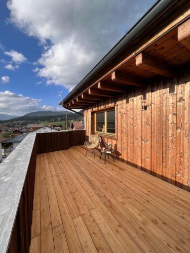 a wooden deck with a chair on top of a building at Chic lodge-apartments in Ehrwald