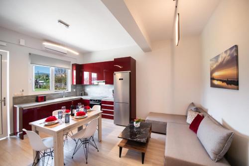 a kitchen and living room with a table and a couch at Ruellia Luxury Apartments in Lefkada Town