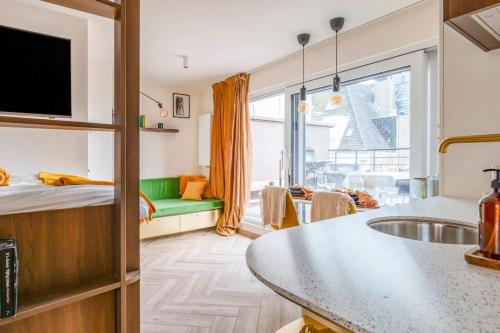 Habitación con cama y cocina con fregadero en Love Nest - Your cosy penthouse en Ostende