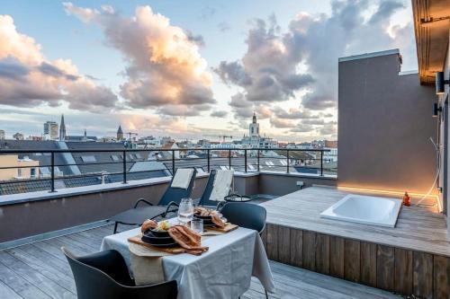 balcón con mesa, sillas y vistas en Love Nest - Your cosy penthouse en Ostende