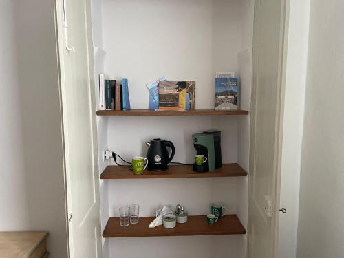 a room with wooden shelves with cups and books at Bed & Breakfast Barbera e Tulipani in Scandeluzza