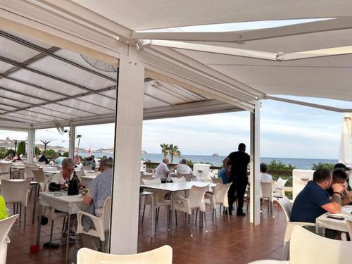 a group of people sitting at tables in a restaurant at Casa La Buena Vida in San Juan de los Terreros
