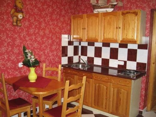 cocina con mesa, fregadero, mesa y sillas en Andrea Apartmanház, en Balatonlelle