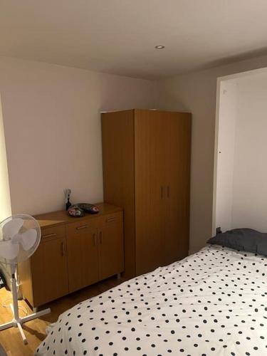 a bedroom with a bed and a wooden cabinet at 1 Bed flat in Central London in London