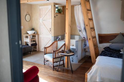 a bedroom with a bed and a chair and a table at Gate Away B&B Units - המקום באל רום in El-Rom