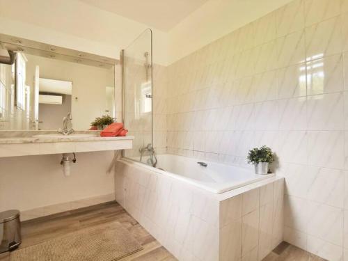 une salle de bain avec une baignoire, un lavabo et un miroir dans l'établissement Les quatre loges - joli t2 jardinet et parking *3, à Aix-en-Provence