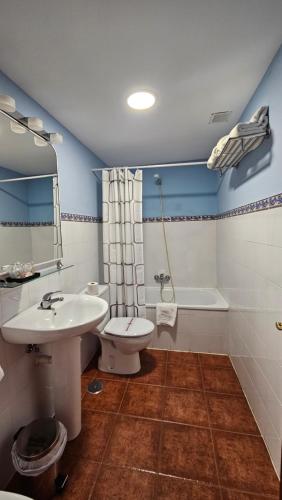 een badkamer met een wastafel, een toilet en een bad bij HOSTAL ALBE in Carrión de los Condes