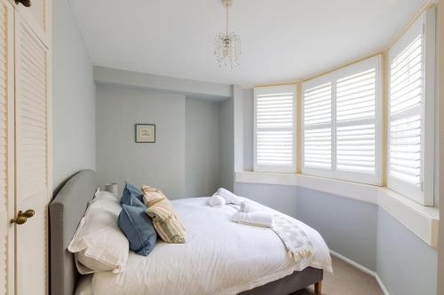 a bedroom with a bed and two windows at Stylish period maisonette flat in centre of Bath in Bath