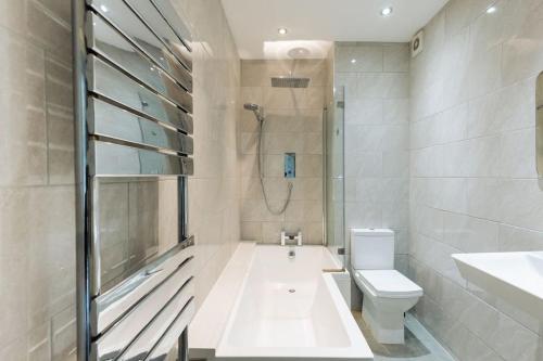 y baño con bañera, aseo y ducha. en Stylish period maisonette flat in centre of Bath en Bath