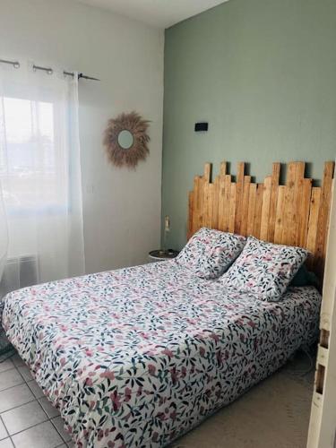 une chambre avec un lit avec une tête de lit en bois dans l'établissement T2 face à la mer en première ligne, à Canet