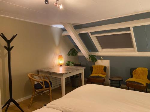 Schlafzimmer mit einem Bett, einem Tisch und Stühlen in der Unterkunft Bed and breakfast Carma Arnhem in Arnhem
