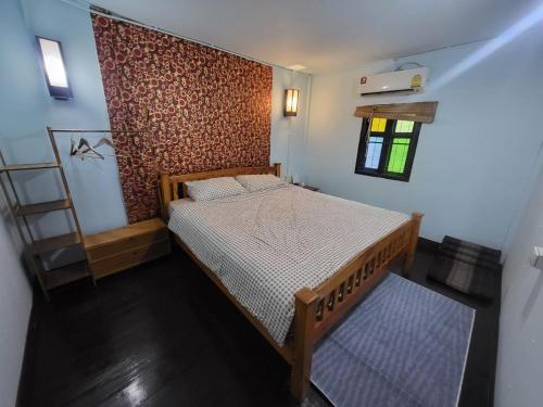 a bedroom with a wooden bed in a room at Punkei home-Chiang Mai Center Near Sunday Market in Chiang Mai