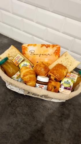 Loft Détente & Spa du Tram في رونتشامب: سلة مليئة بأنواع مختلفة من الخبز والوجبات الخفيفة