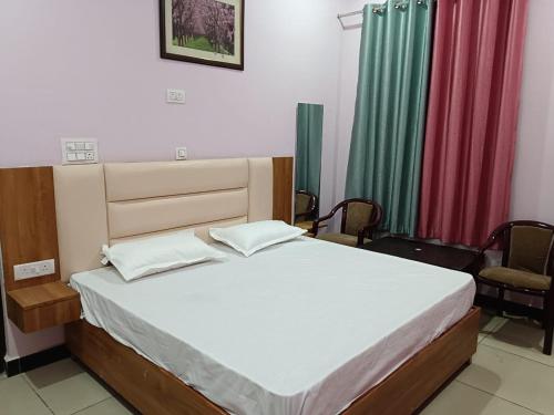 a bedroom with a bed and two chairs at Holy Homestay in Faizābād