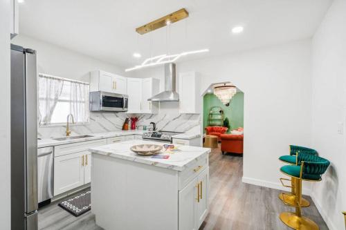a kitchen with white cabinets and a green wall at NEW! Havana Nights Villa ! Walk to Calle Ocho! in Miami