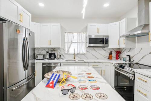 a kitchen with white cabinets and a white counter top at NEW! Havana Nights Villa ! Walk to Calle Ocho! in Miami