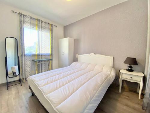 une chambre avec un grand lit blanc et une table dans l'établissement Appartement pour 4 vue sur la marina de Canet, à Canet