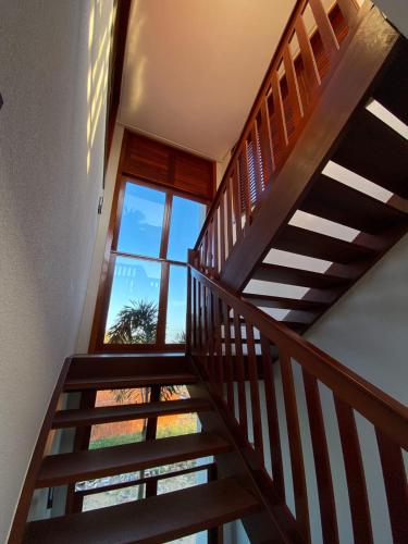 a wooden staircase with a view of a window at Villa Palmeira Flecheiras 201 in Flecheiras