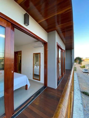 a balcony of a house with a bed and windows at Villa Palmeira Flecheiras 201 in Flecheiras
