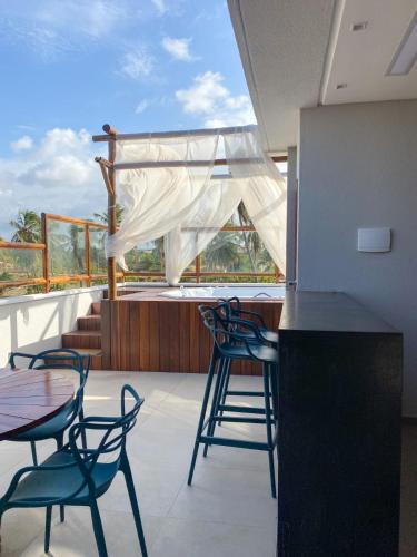 a balcony with chairs and a table and a counter at Villa Palmeira Flecheiras 201 in Flecheiras