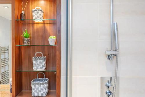 a bathroom with a wooden shelf with baskets on it at Pass the Keys Granary Wharf Deluxe - balcony and rooftop garden in Leeds