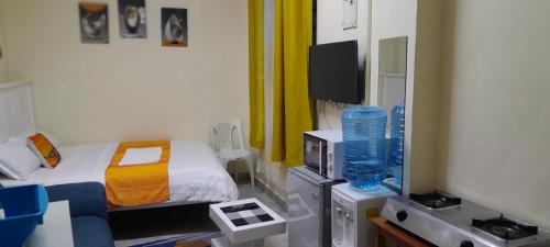 Habitación pequeña con cama y TV. en Goldneststays, en Nairobi