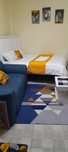a bedroom with a bed and a couch in it at Goldneststays in Nairobi