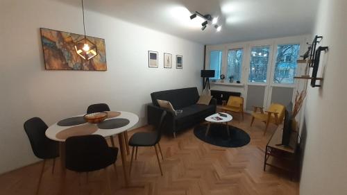 a living room with a couch and a table and chairs at Krzemieniecka Atlas Arena Zoo Orientarium in Łódź